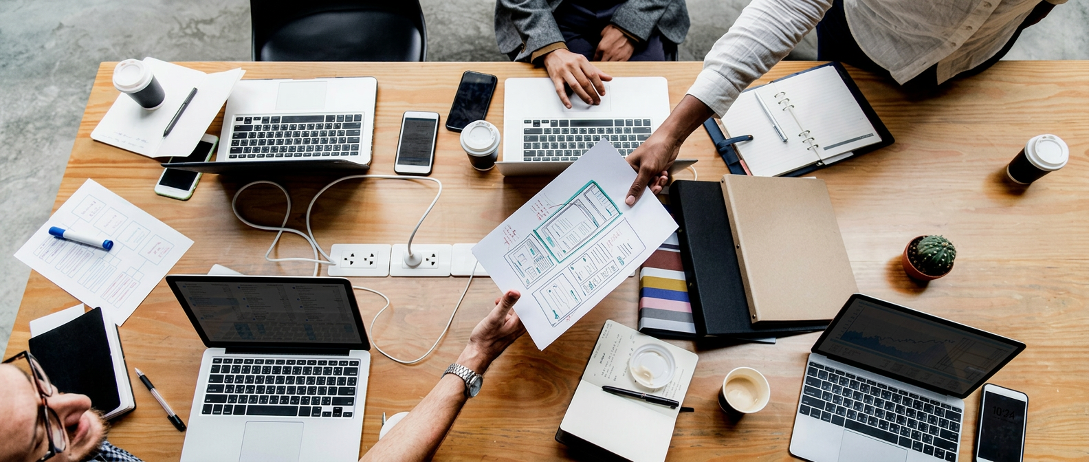 Team reviewing documents and reports around a meeting table