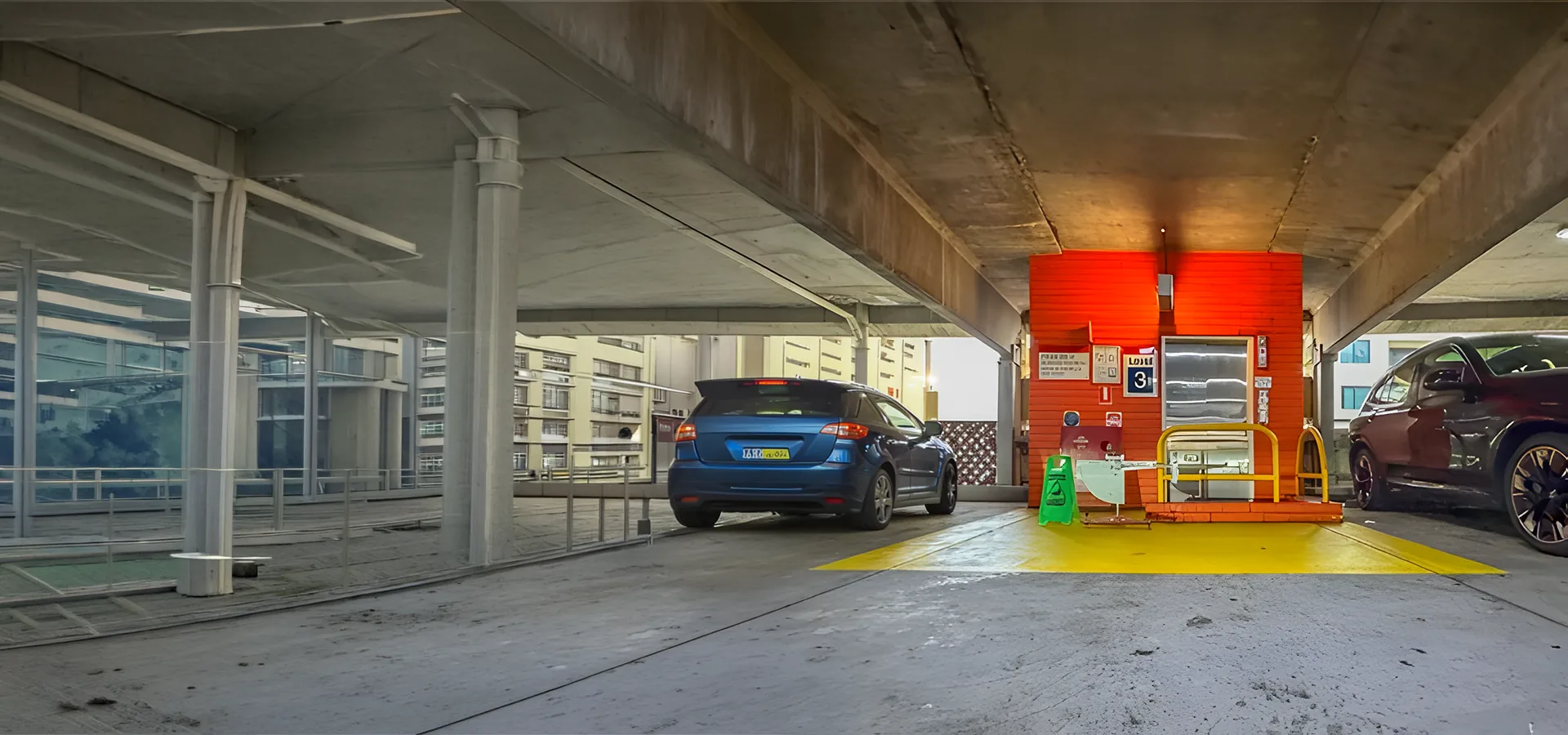 Multi storey car park lift lobby with yellow line marked pavement and slip testing equipment in place